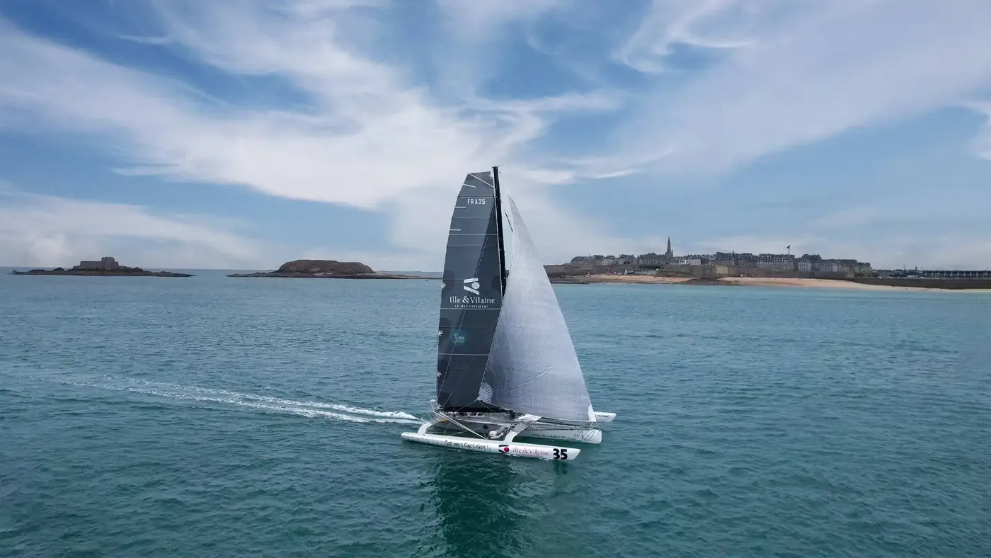 Trimaran sous voiles devant la côte malouine